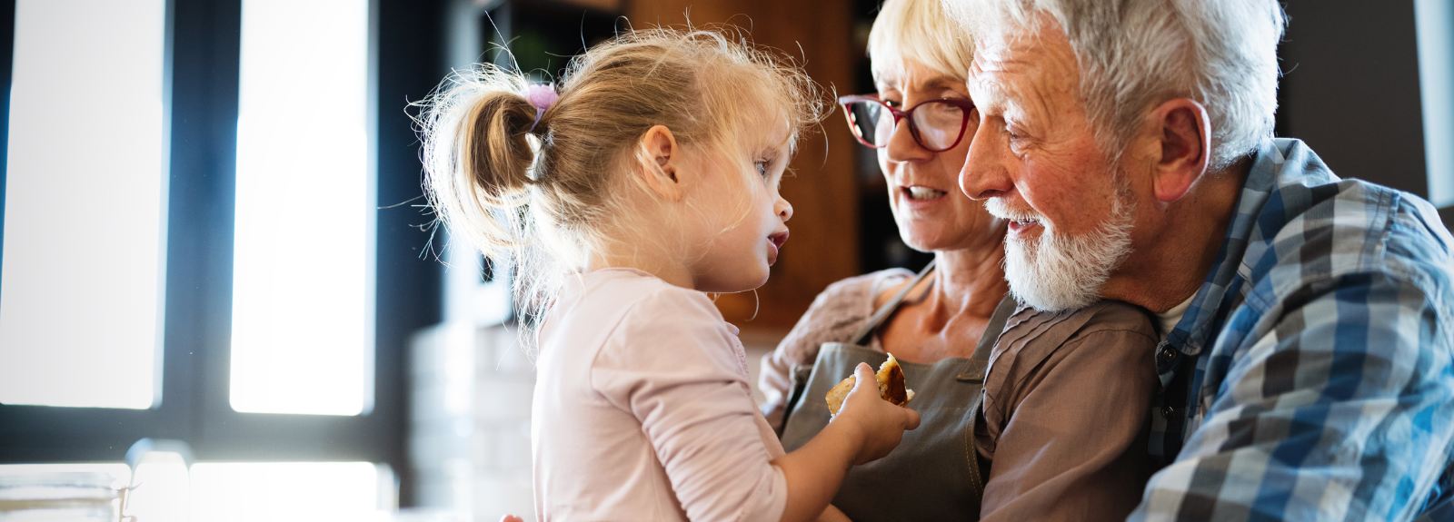 Grandparents holding and looking adoringly at with small girl